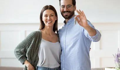 Pareja con llaves de su nueva casa en la mano.